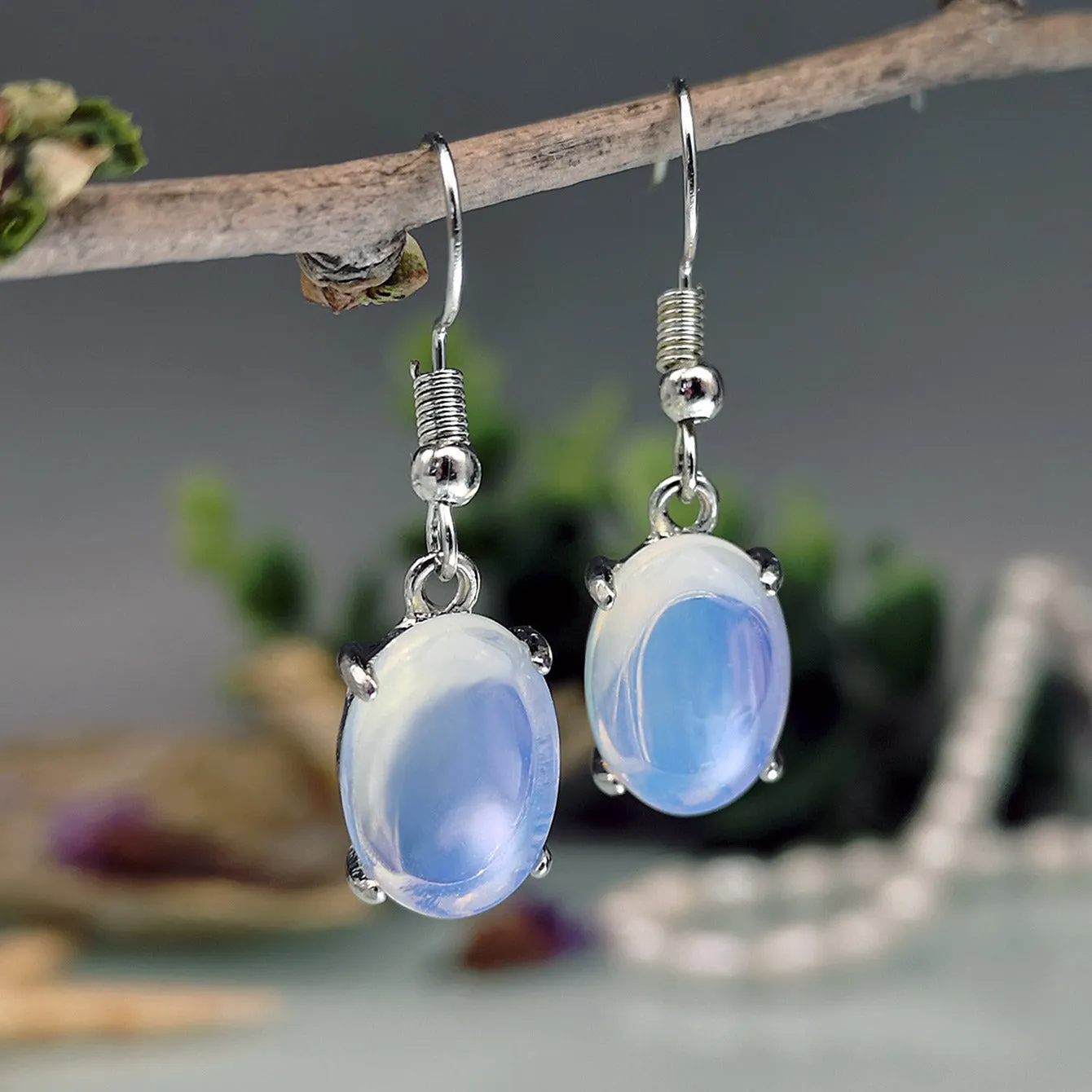 A pair of opal drop earrings with a retro moonstone design and electroplated alloy finish in a moonlight white colour.
