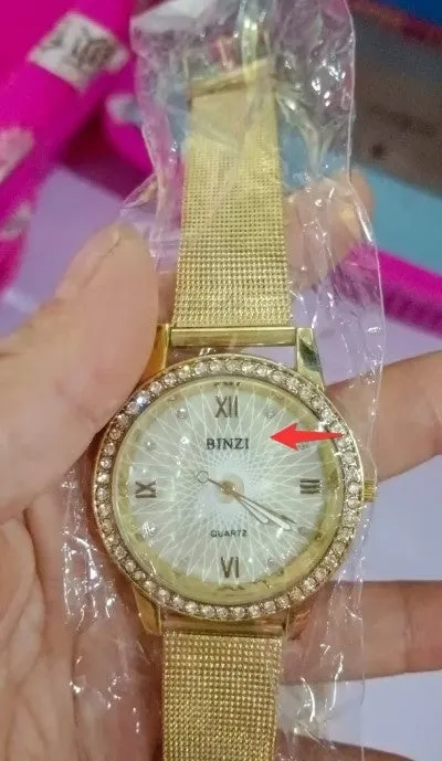 Golden mesh strap alloy electronic watch with round dial and world time GMT functions on a plain background