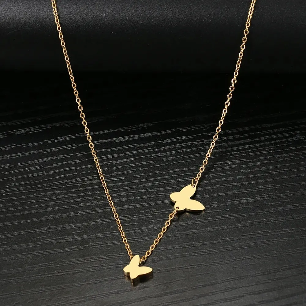 Butterfly pendant necklace in stainless steel with 18K gold electroplated finish on a white background