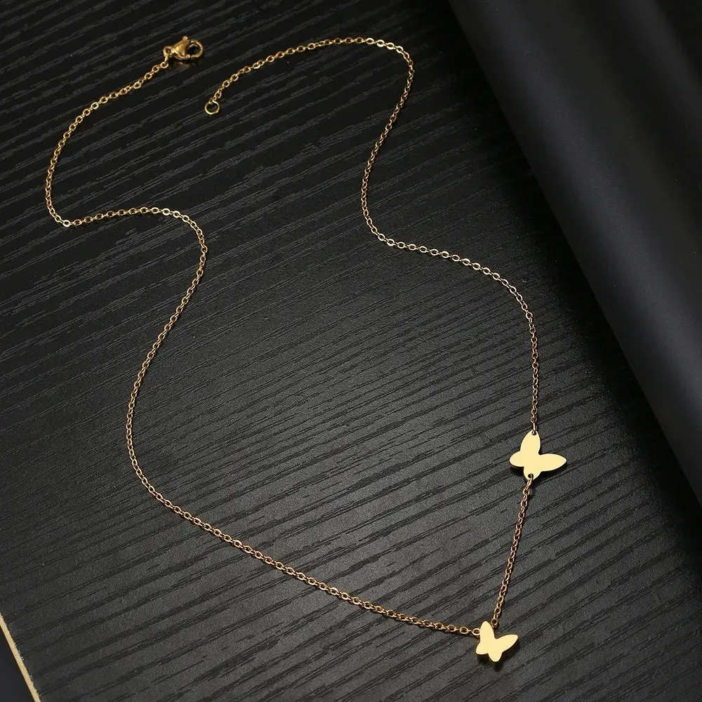 Butterfly pendant necklace in stainless steel with 18K gold electroplated finish on a white background