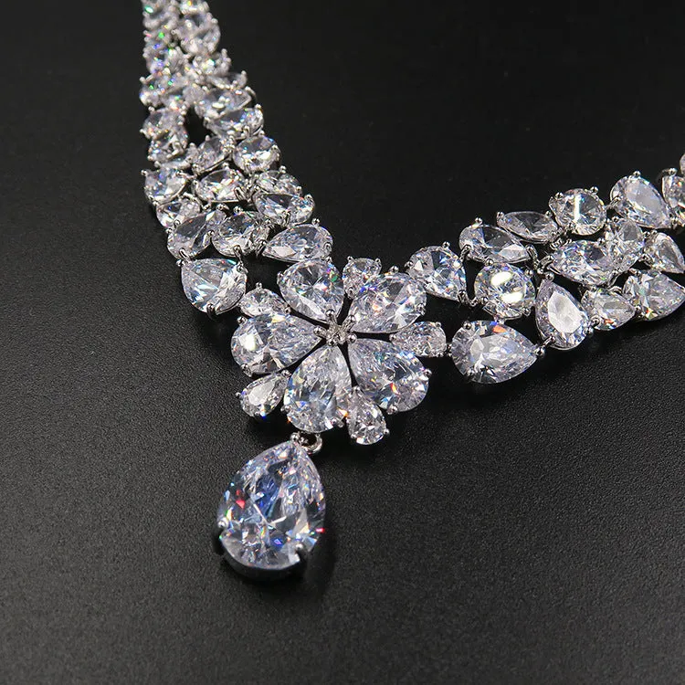 Three piece bridal jewellery set with gold leaf crown necklace and earrings on white background