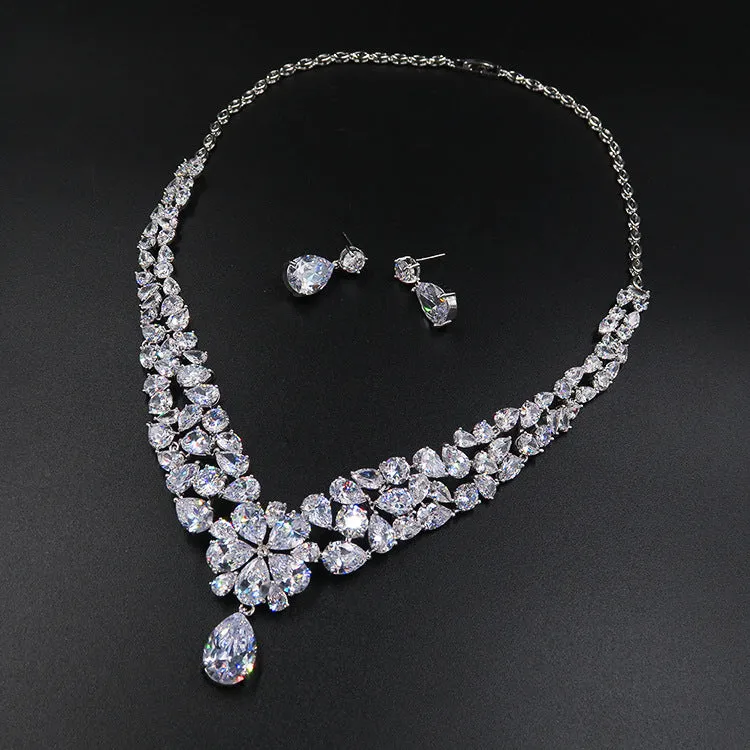 Three piece bridal jewellery set with gold leaf crown necklace and earrings on white background