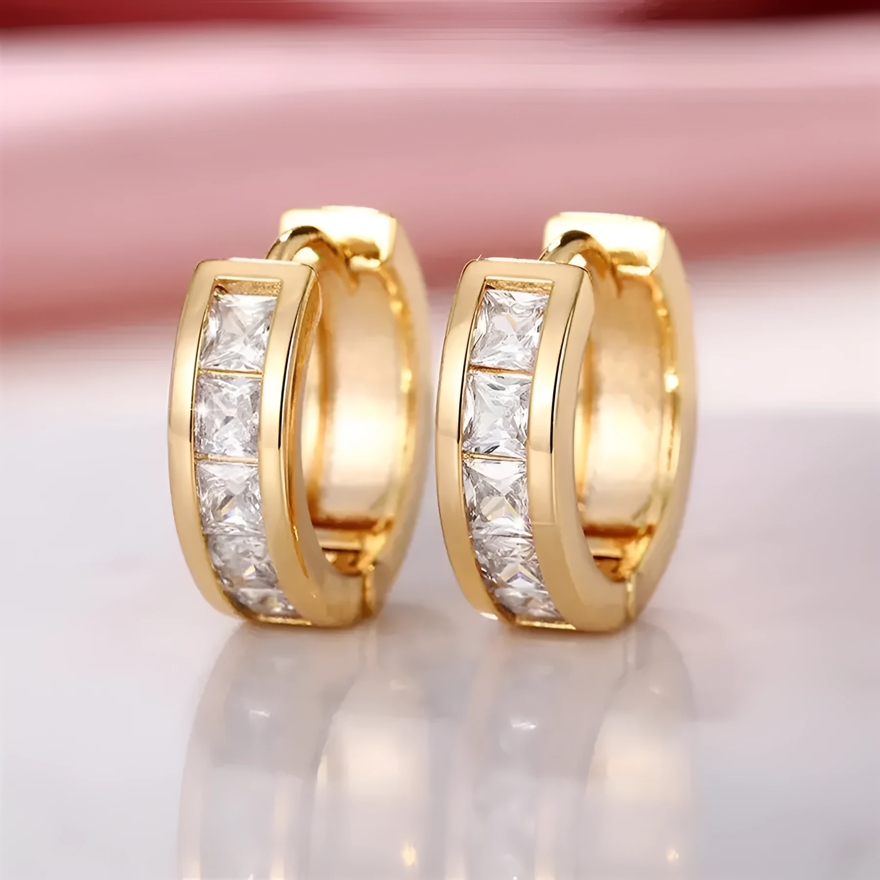 A pair of geometric quadrilateral earrings for women in a gold tone, showing the post and butterfly clutch back.