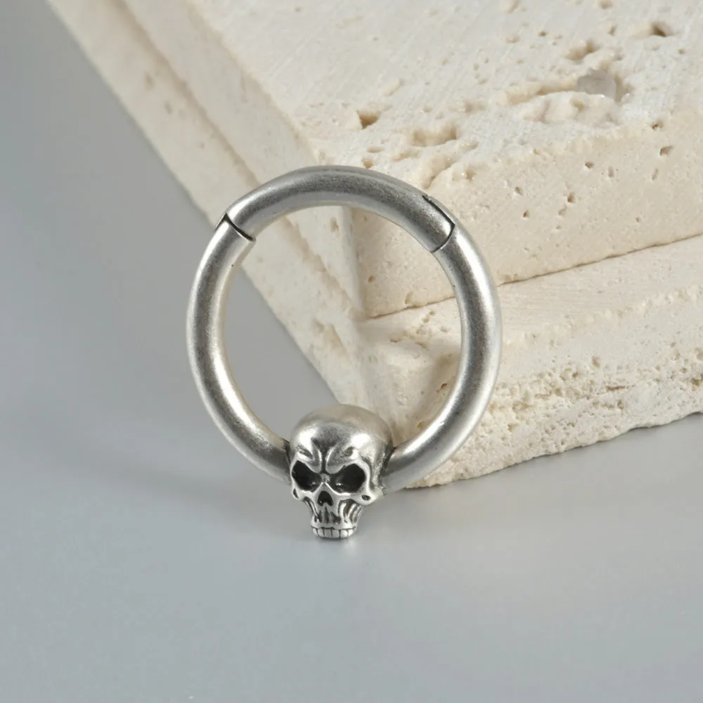 A pair of antique silver copper punk earrings featuring three small detailed ghost heads on a horizontal bar.