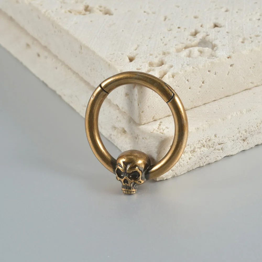 A pair of antique silver copper punk earrings featuring three small detailed ghost heads on a horizontal bar.