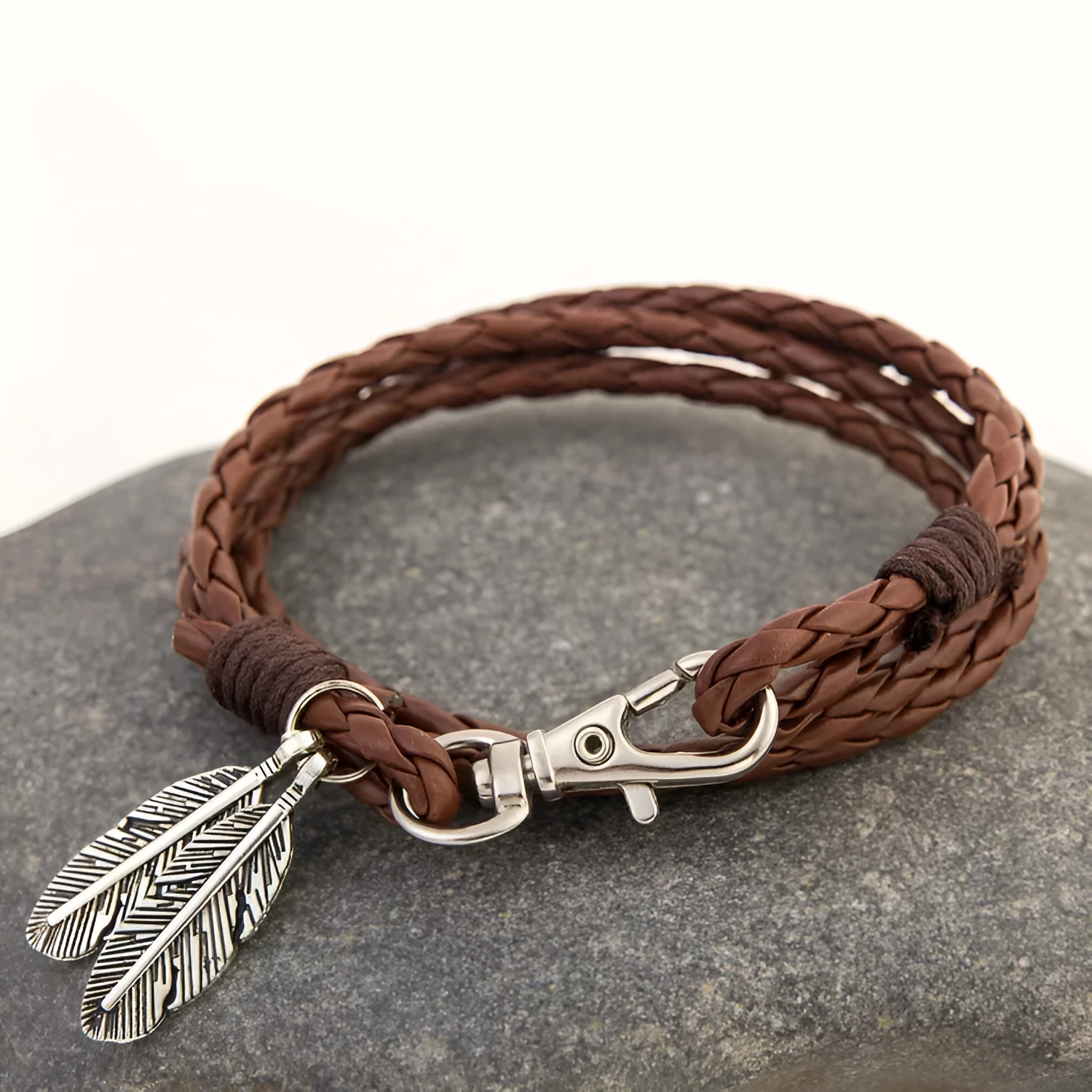 Leather charm friendship bracelet with buckle closure in black brown on white background