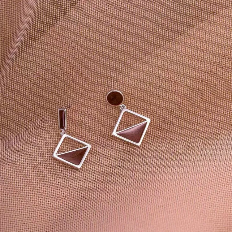 925 silver asymmetrical love earrings with frosty electroplated brown finish on a light background
