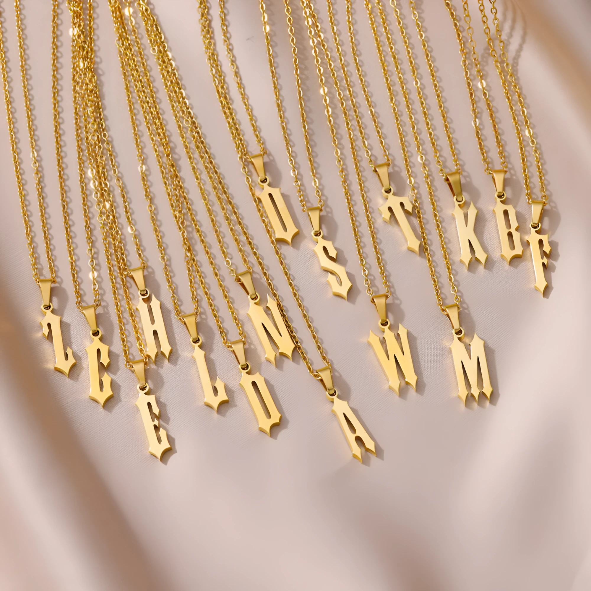 Gold stainless steel ancient English letter pendant necklace with O-ring chain on white background