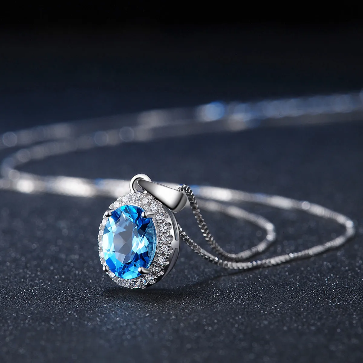 Four-piece sterling silver jewellery set with blue topaz: geometric earrings, ring, pendant, and necklace.