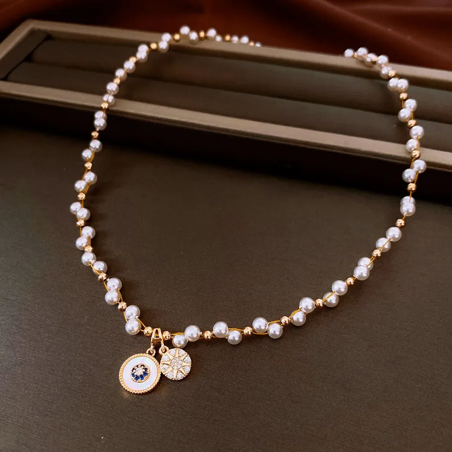Gold electroplated necklace with round imitation pearl pendant and Chinese style geometric design