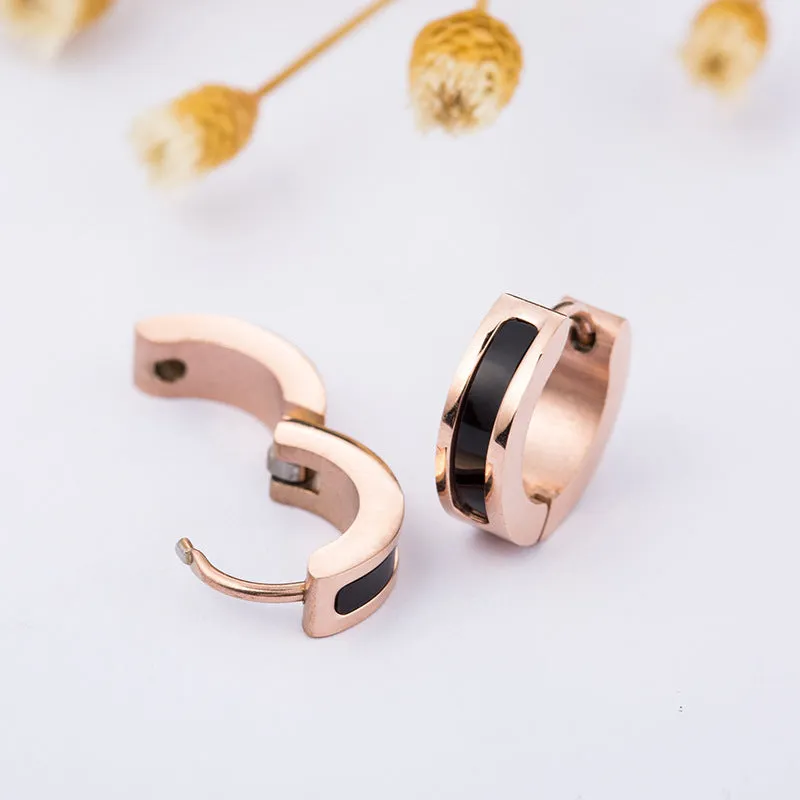 Pair of black titanium steel earrings with geometric shell inlay on white background