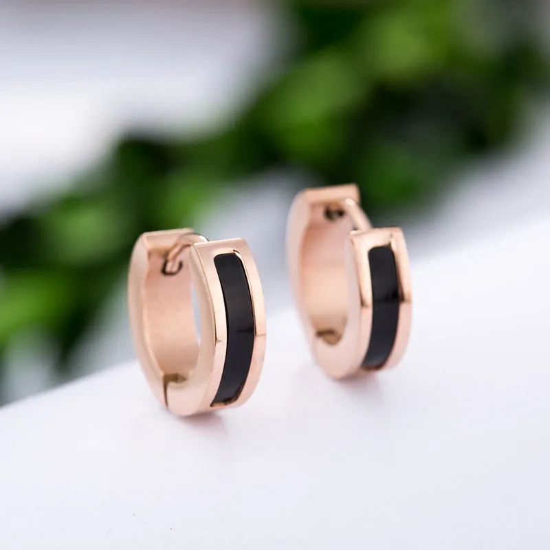 Pair of black titanium steel earrings with geometric shell inlay on white background