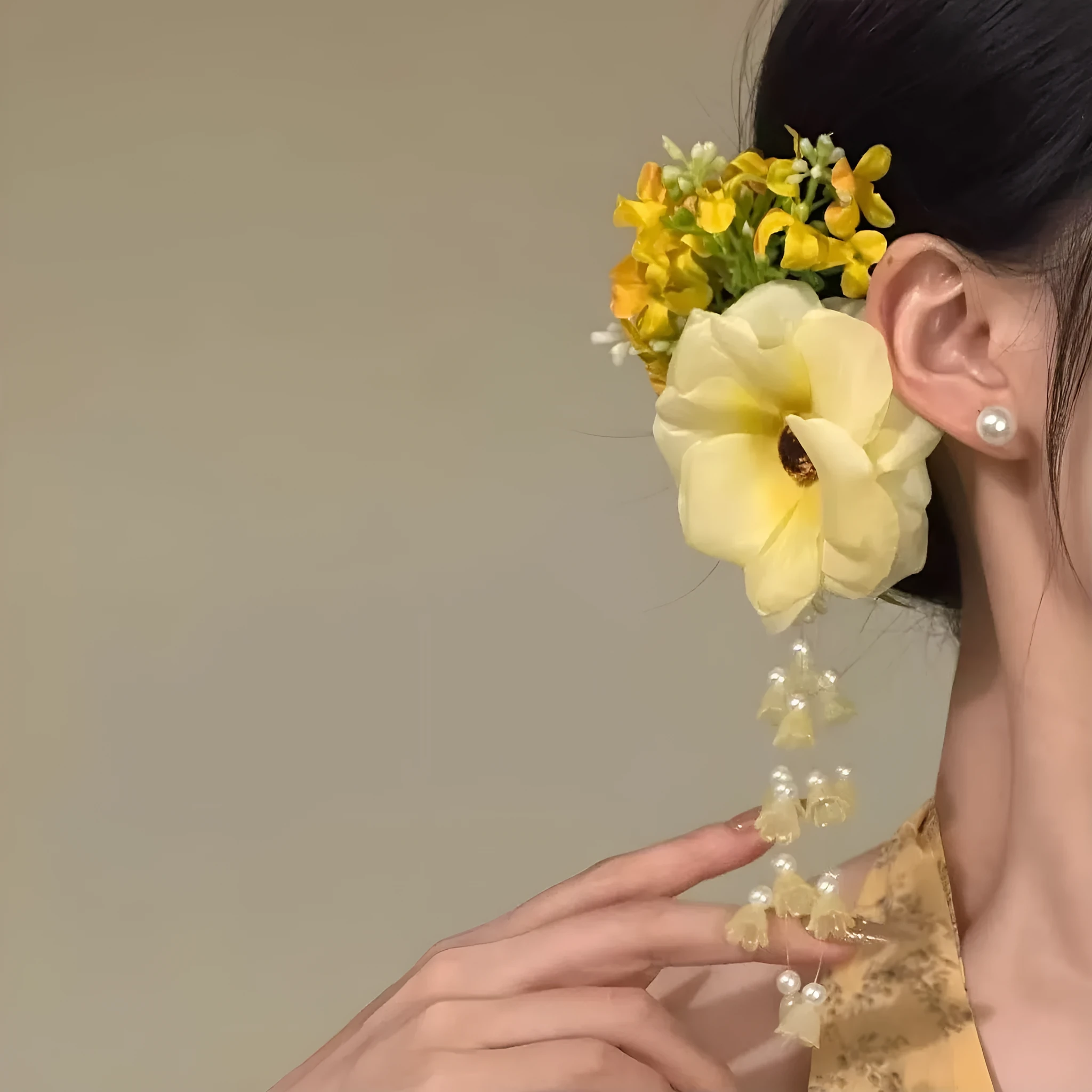 Yellow flower tassel side clip hair accessory for women on a purple background.
