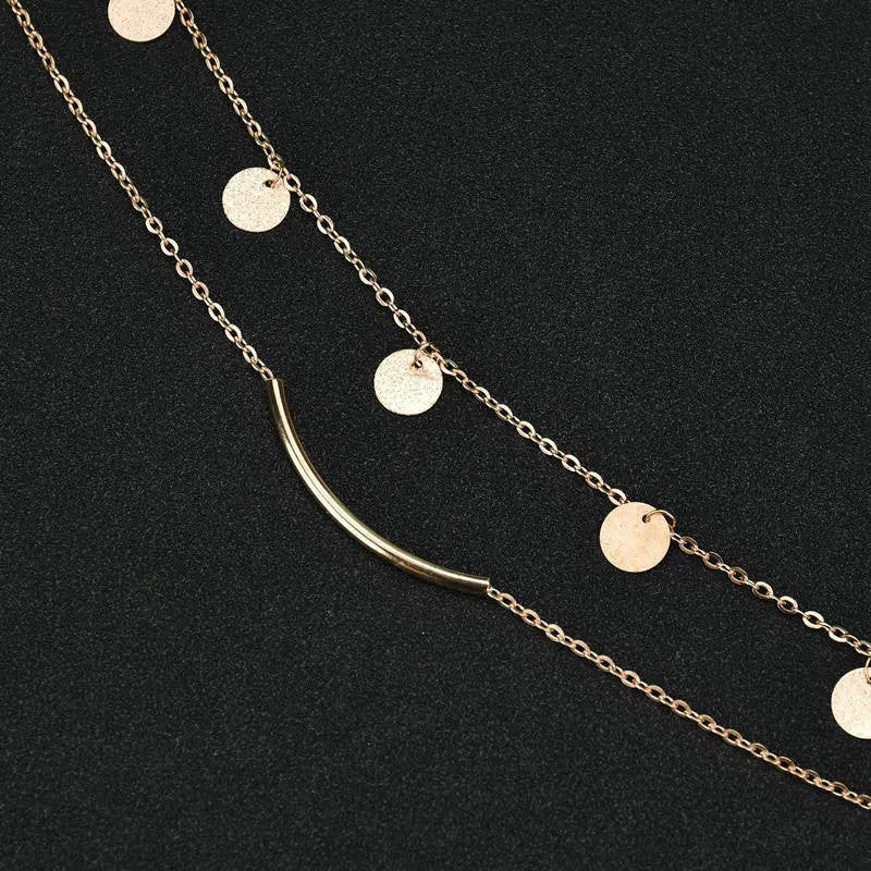 Gold alloy geometric pendant necklace with multi-sequin finish on display