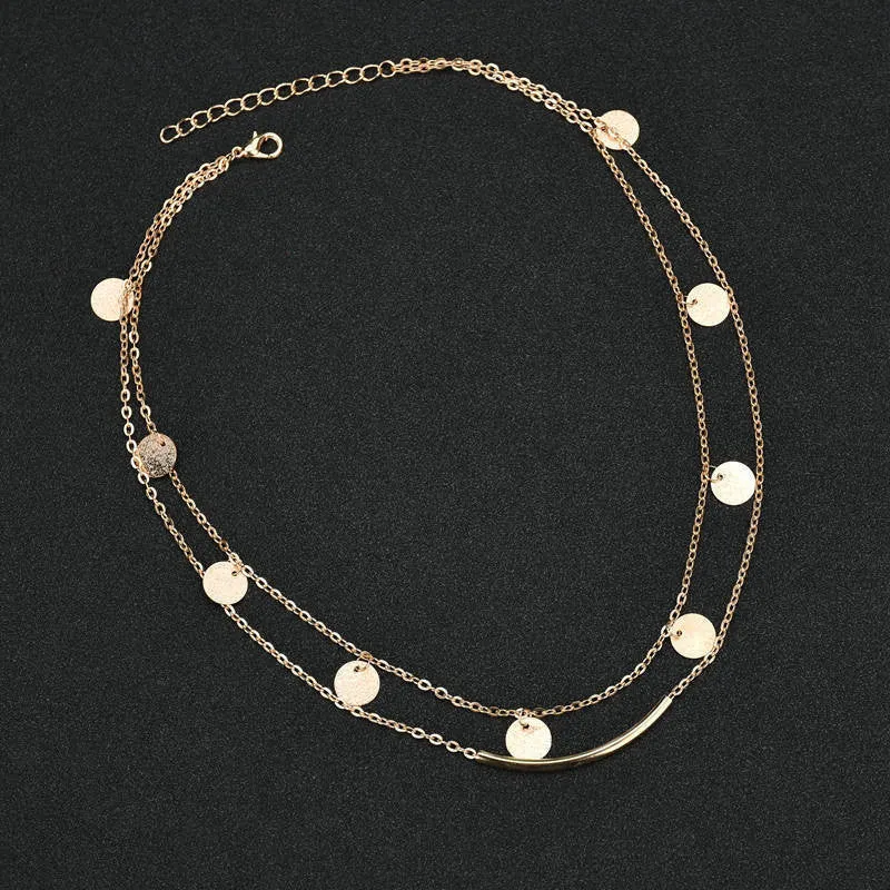 Gold alloy geometric pendant necklace with multi-sequin finish on display