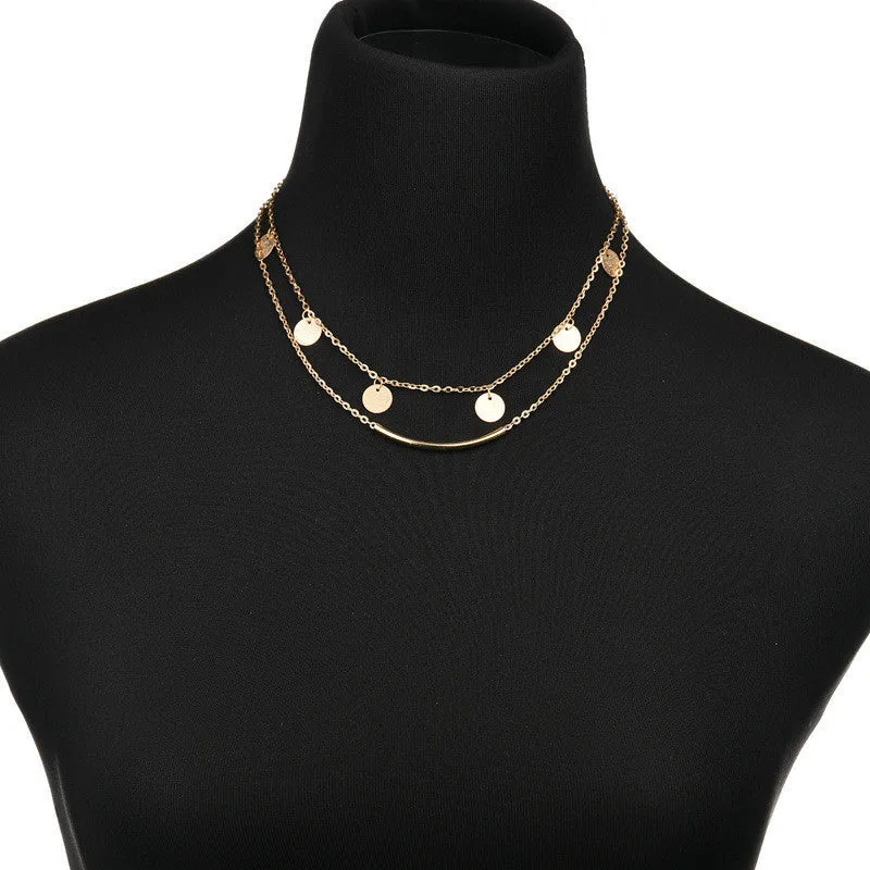 Gold alloy geometric pendant necklace with multi-sequin finish on display