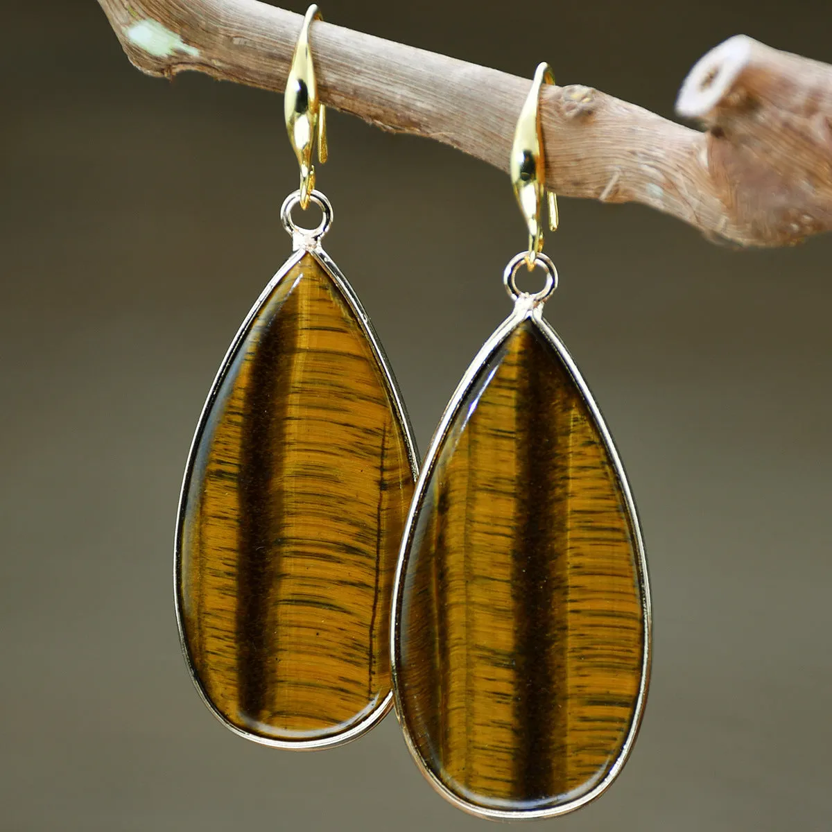 Vintage long water drop earrings in tigereye stone with textured surface and dangle silhouette
