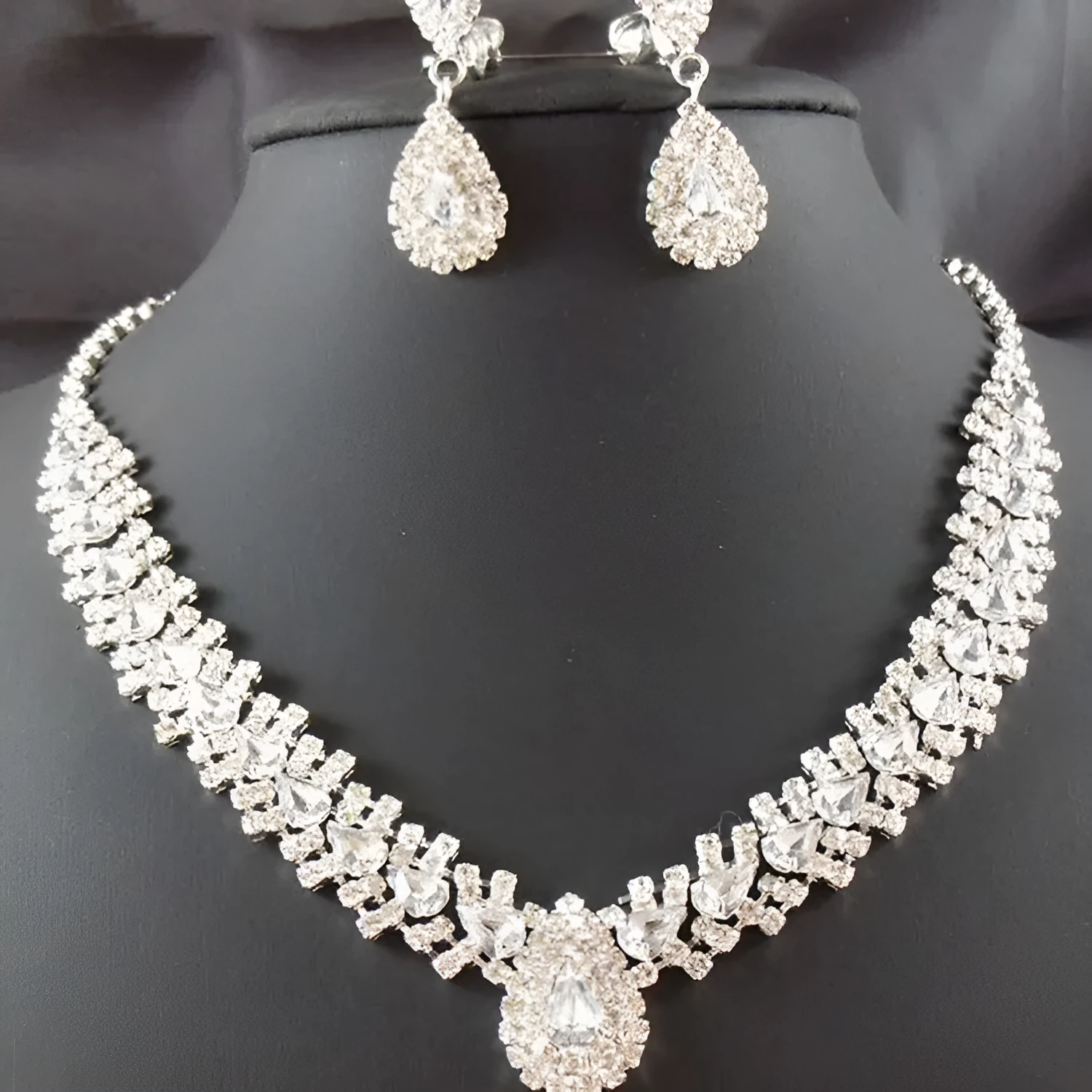 Gold bride wedding accessories set with drop earrings and necklace on white background