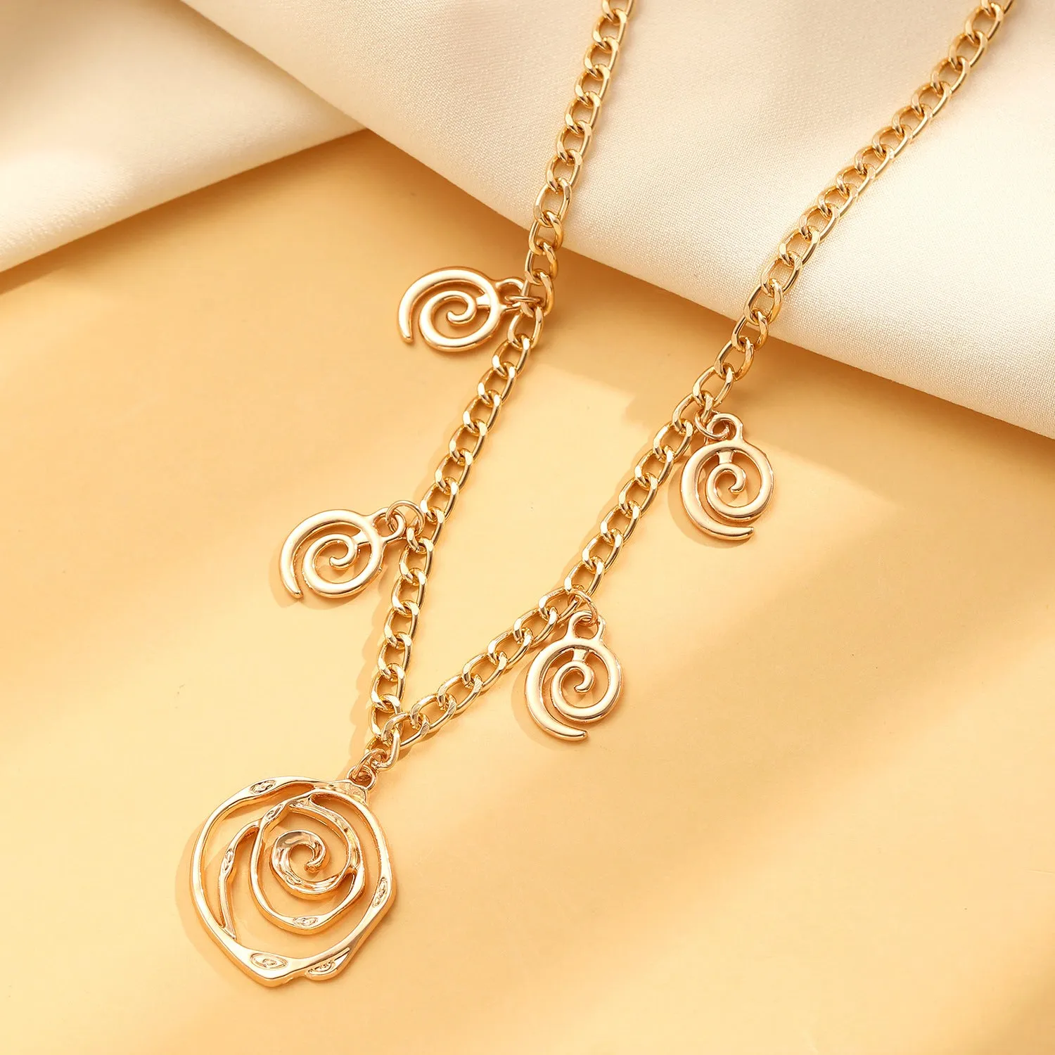 Spiral donut jewellery set showing necklace, bracelet, and ear hooks in gold or silver tone alloy