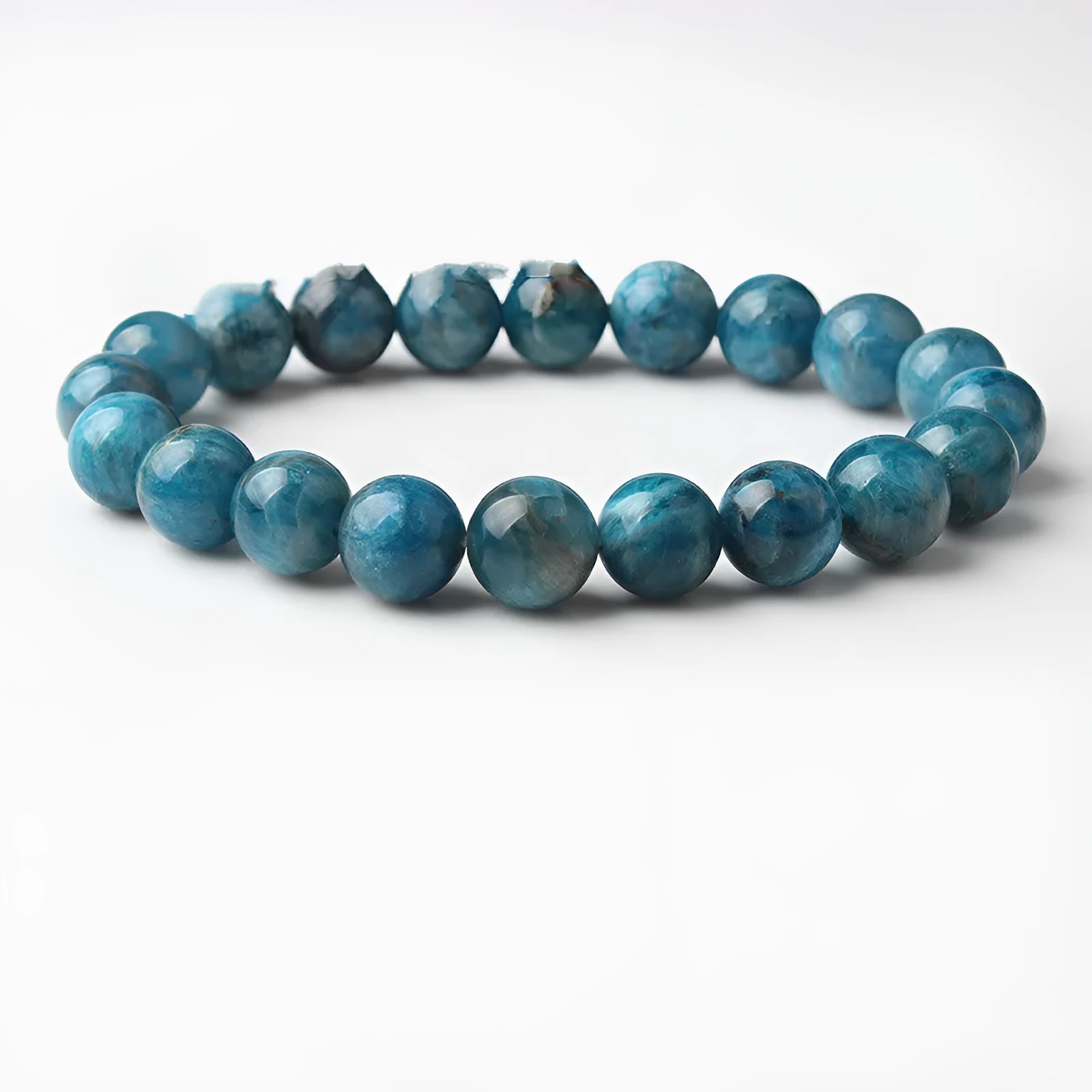 Natural blue apatite elastic beaded bracelet with polished round beads, unisex design, shown on a neutral background