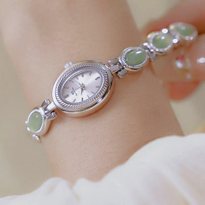 Women's bracelet watch with oval alloy case, natural stone inlay, and mineral glass dial.