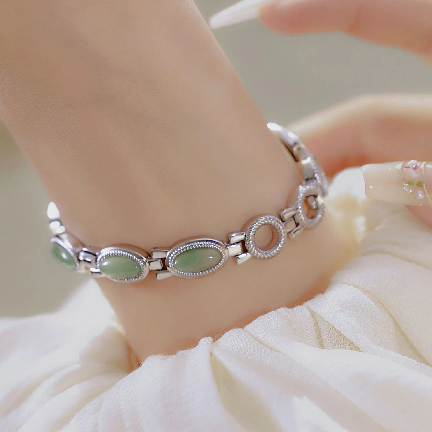 Women's bracelet watch with oval alloy case, natural stone inlay, and mineral glass dial.