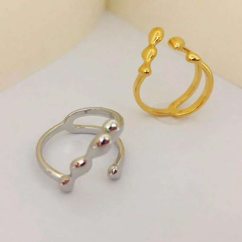 Adjustable brass ring with sphere design in gold or silver plating.