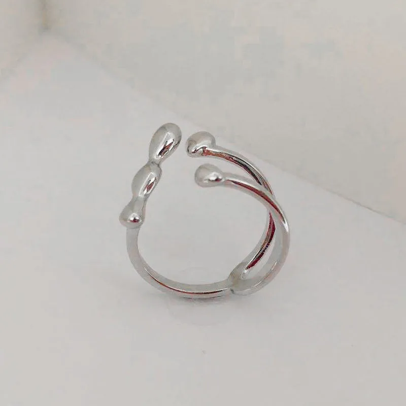 Adjustable brass ring with sphere design in gold or silver plating.