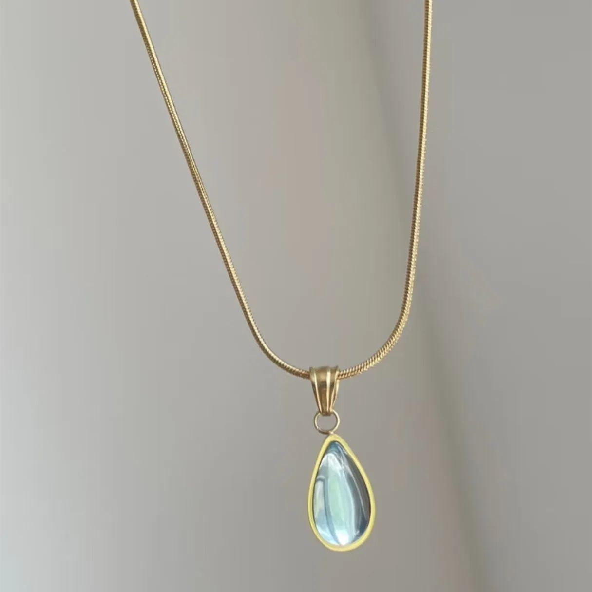 Retro water drop necklace for women with blue gemstone pendant on titanium steel snake bone chain.