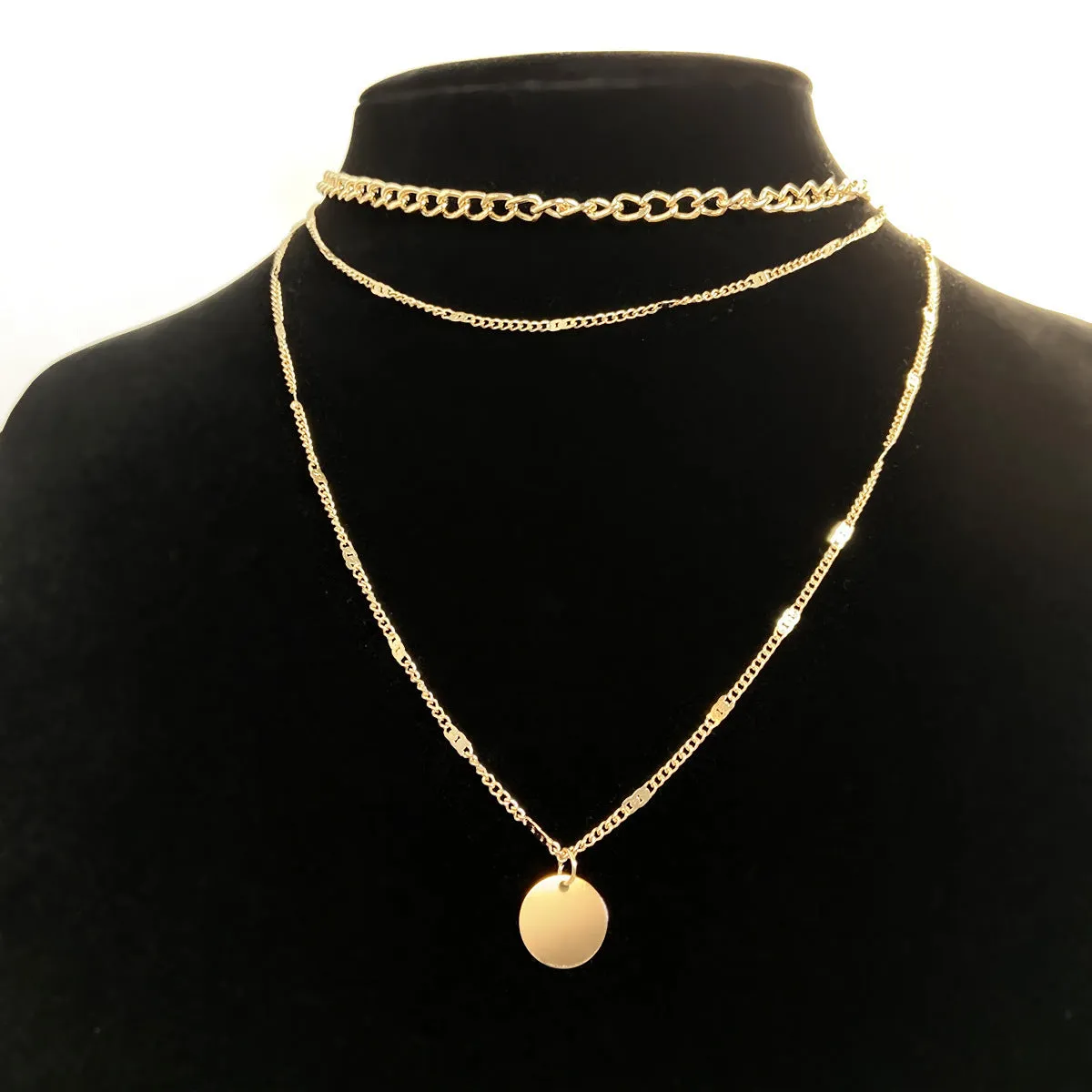 Women's multilayer disc pendant clavicle necklace in gold and silver colour finish on a light background