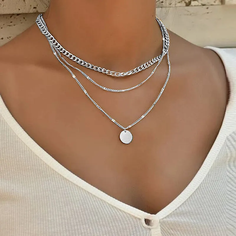 Women's multilayer disc pendant clavicle necklace in gold and silver colour finish on a light background