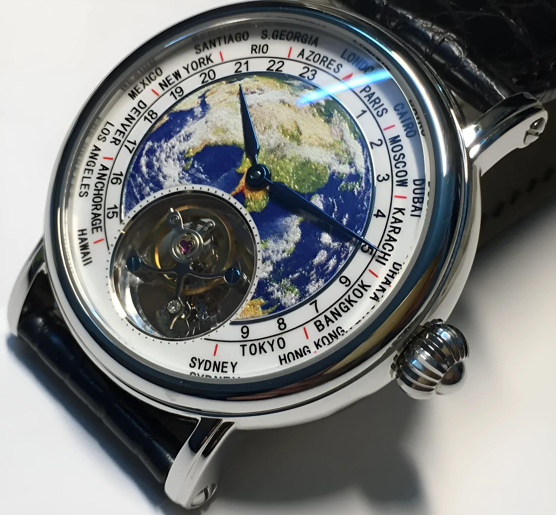 Silver 3D globe tourbillon mechanical watch with leather band and stainless steel case on white background