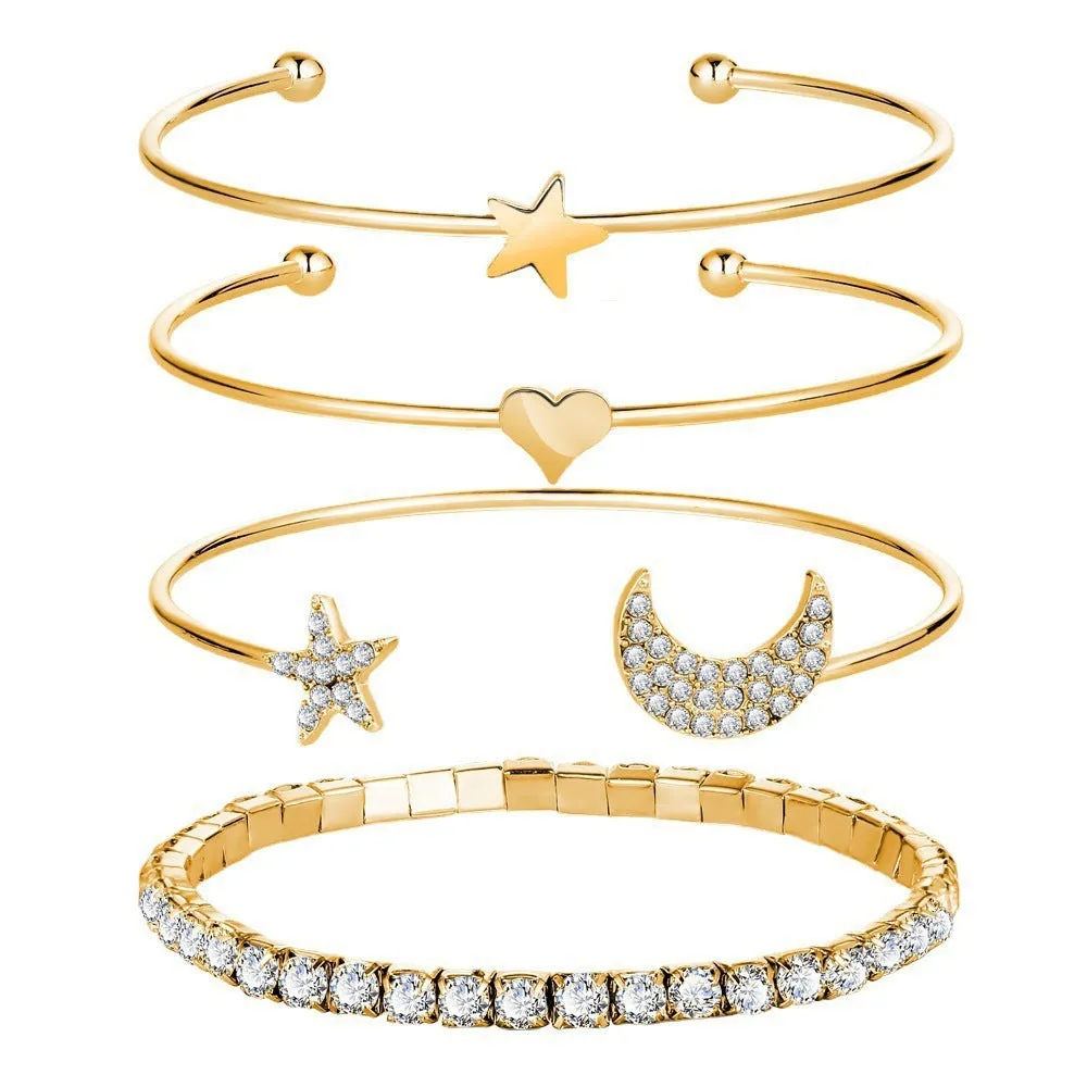 Four gold and silver metal cuff bracelets with moon and star designs on a plain background