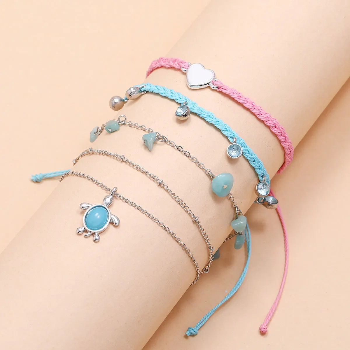 Hand-woven blue love foot rope natural gravel anklet in alloy with geometric shape on a woman's ankle