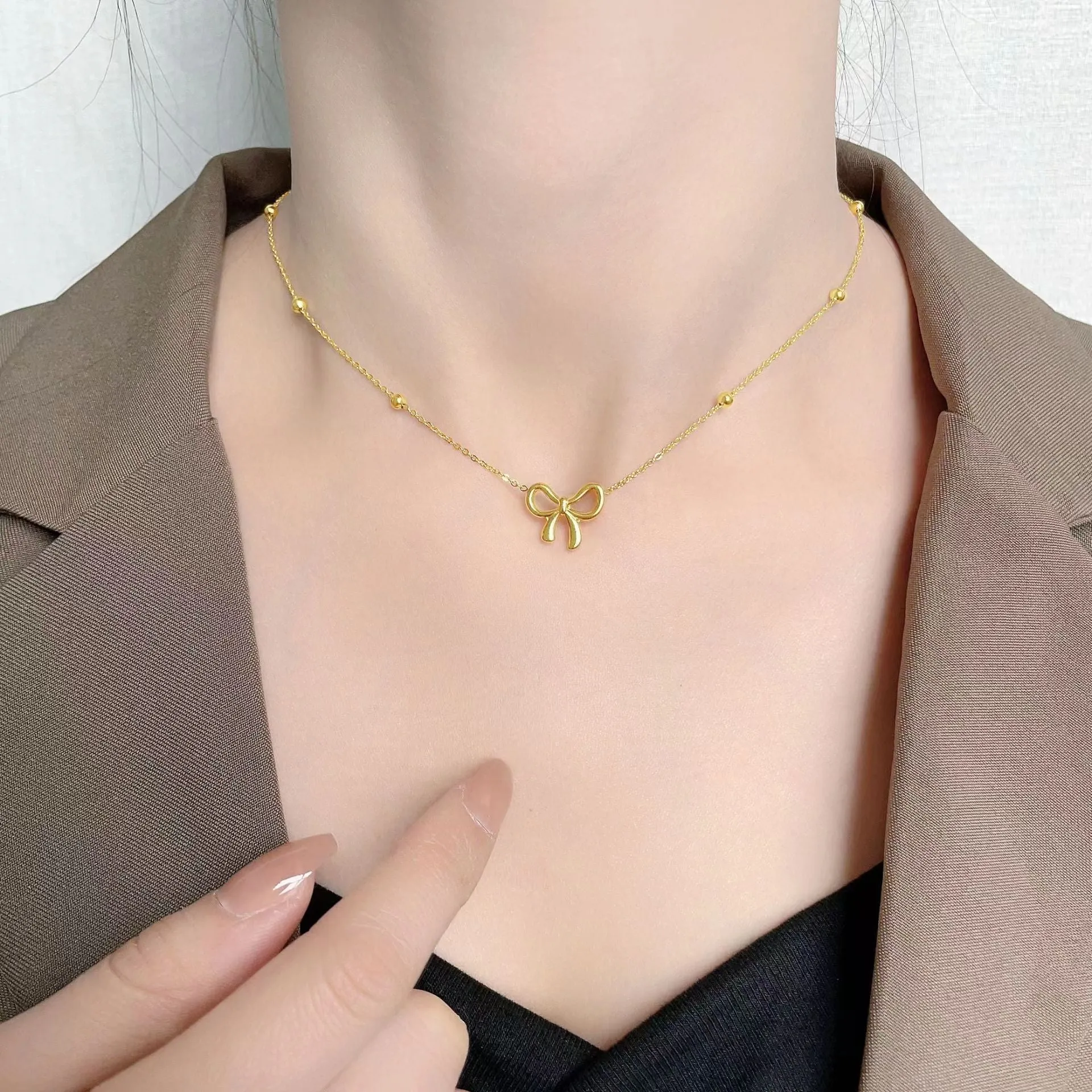 Gold electroplated bow necklace with cross chain design on adjustable 41-50cm chain