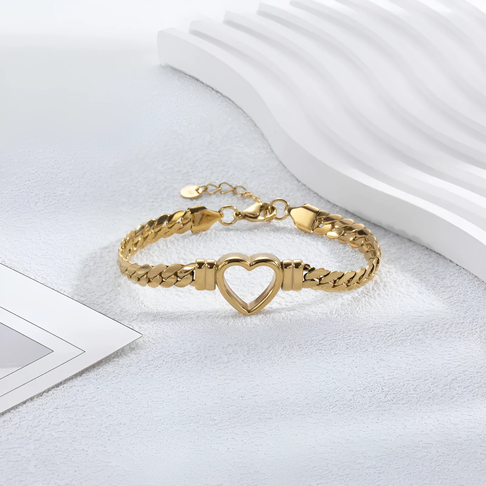 Fashion simple hollow heart titanium steel bracelet in BR-26 gold finish on a neutral background