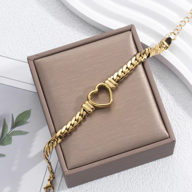 Fashion simple hollow heart titanium steel bracelet in BR-26 gold finish on a neutral background