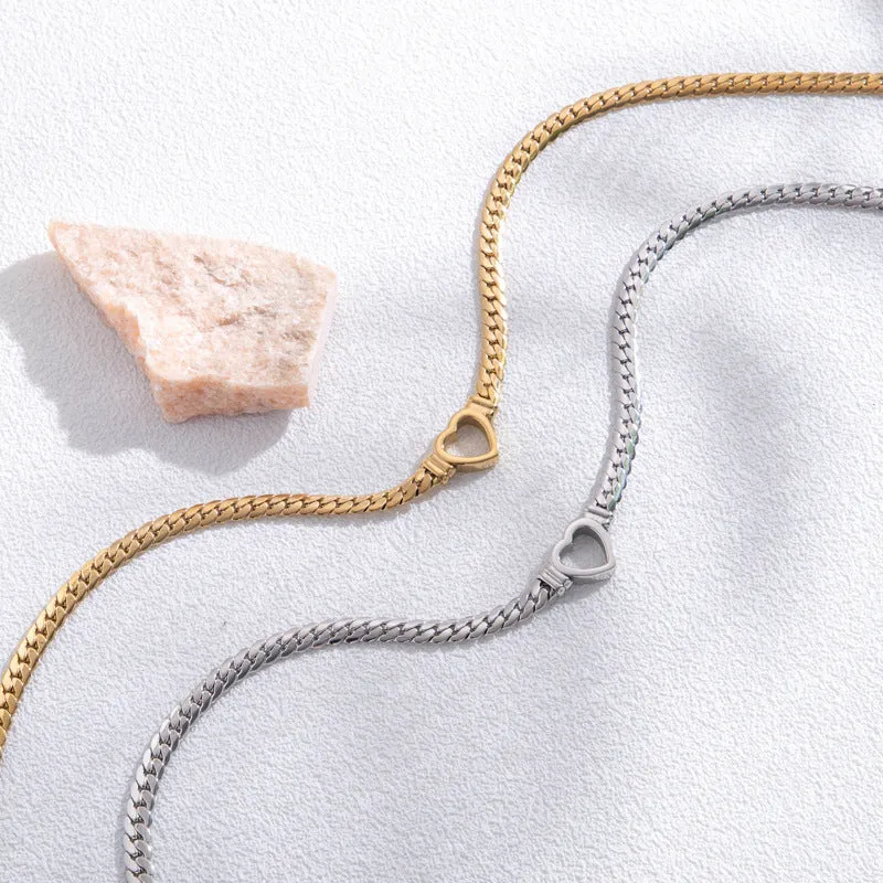 Fashion simple hollow heart titanium steel bracelet in BR-26 gold finish on a neutral background