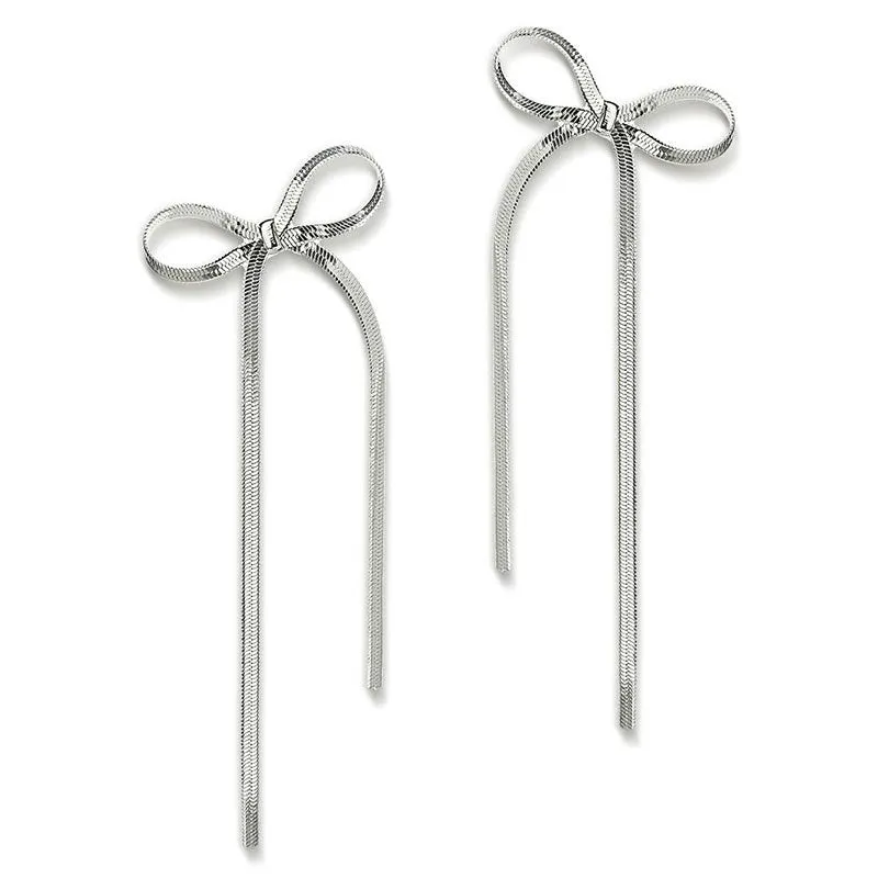 Gold plated bow ribbon dangle earrings with tassel tails on white background