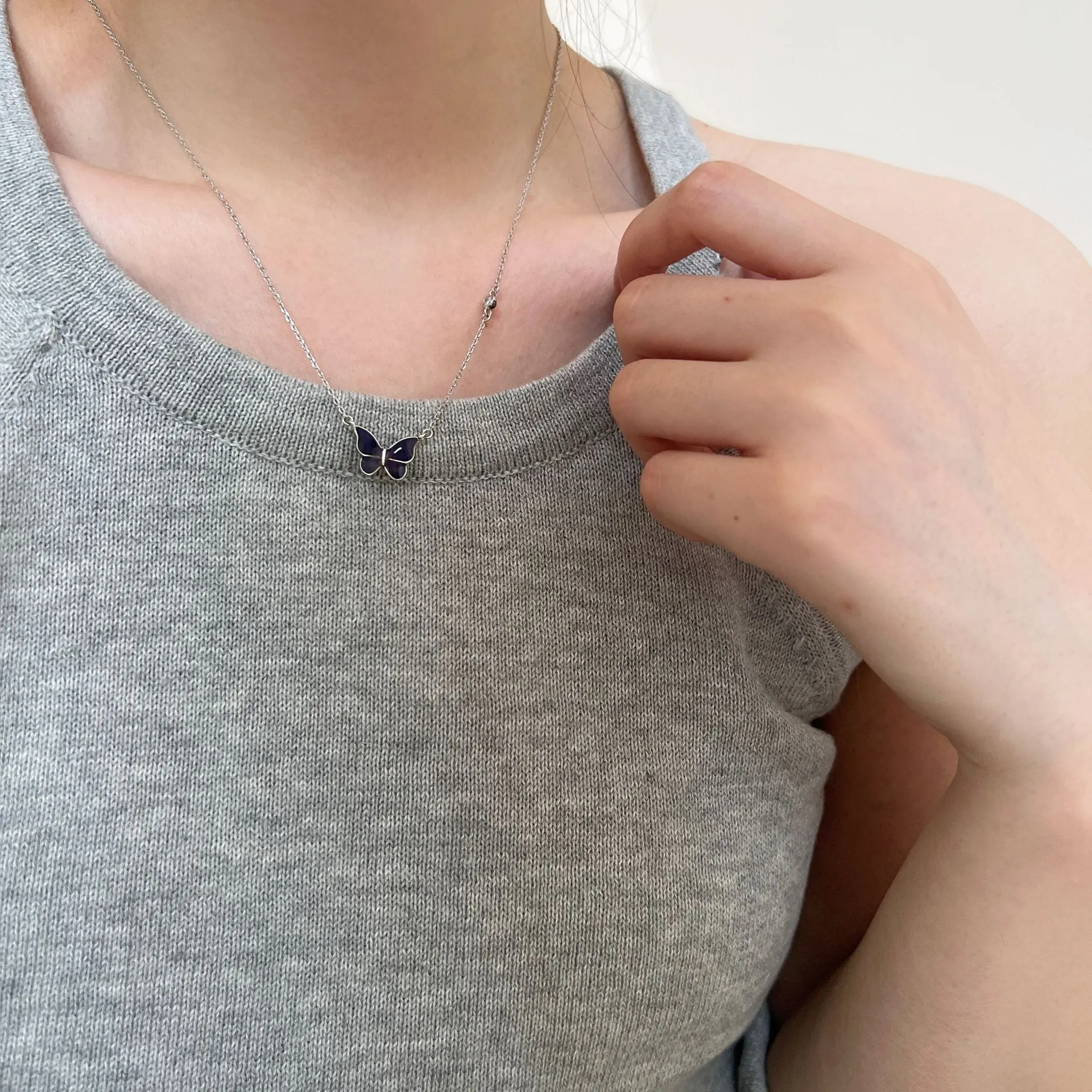S925 silver butterfly necklace with white silver colour-change pendant on display