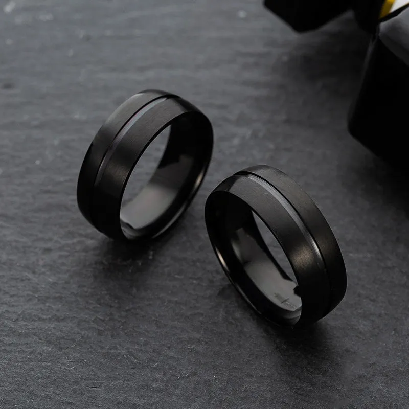 Black titanium steel ring with geometric design and alloy inlaid artificial stone on a dark background.