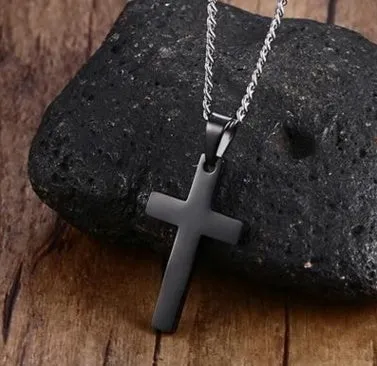 Stainless steel titanium alloy cross pendant on a black whip chain against a dark background