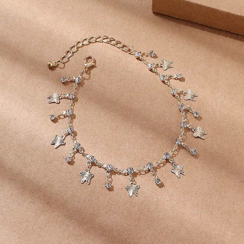 Gold alloy butterfly tassel anklet with colourful floral and leaf design on foot for summer beach wear