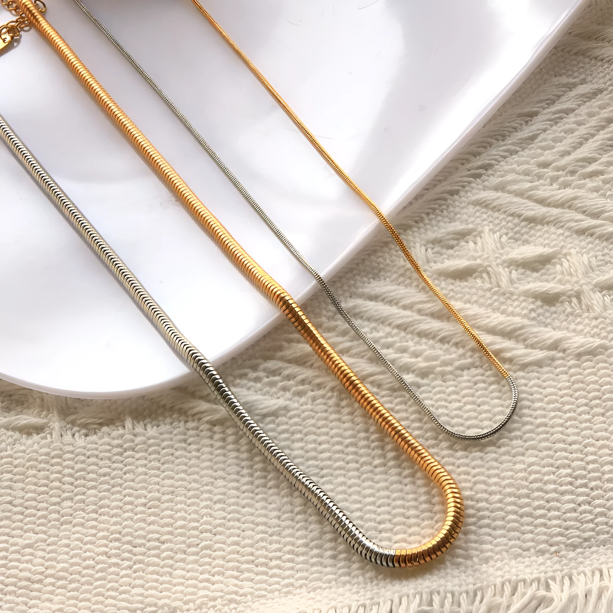 Gold-coloured stainless steel snake bone chain necklace with geometric design, 3mm width.