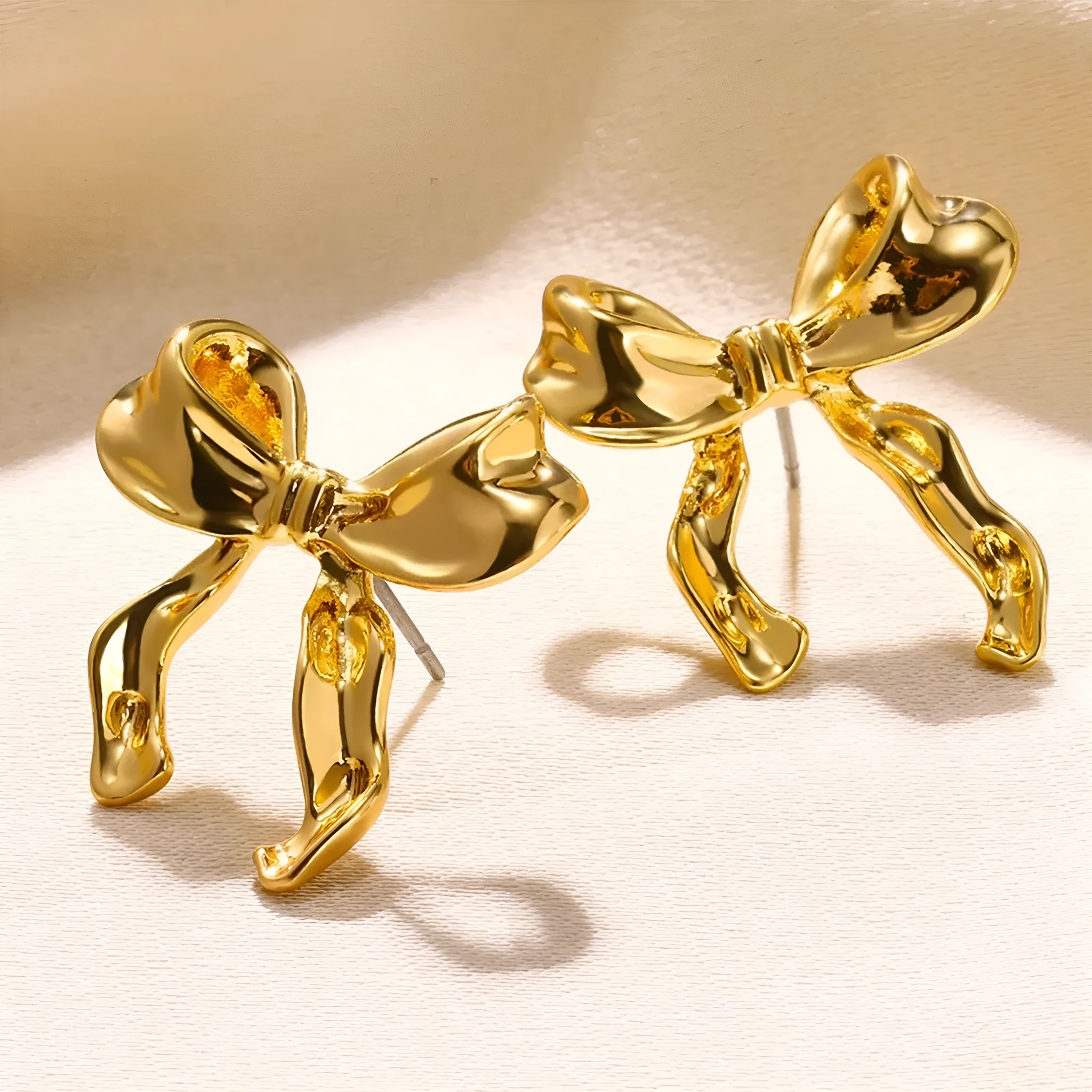 Gold bow earrings simple style alloy electroplated finish pair on white background
