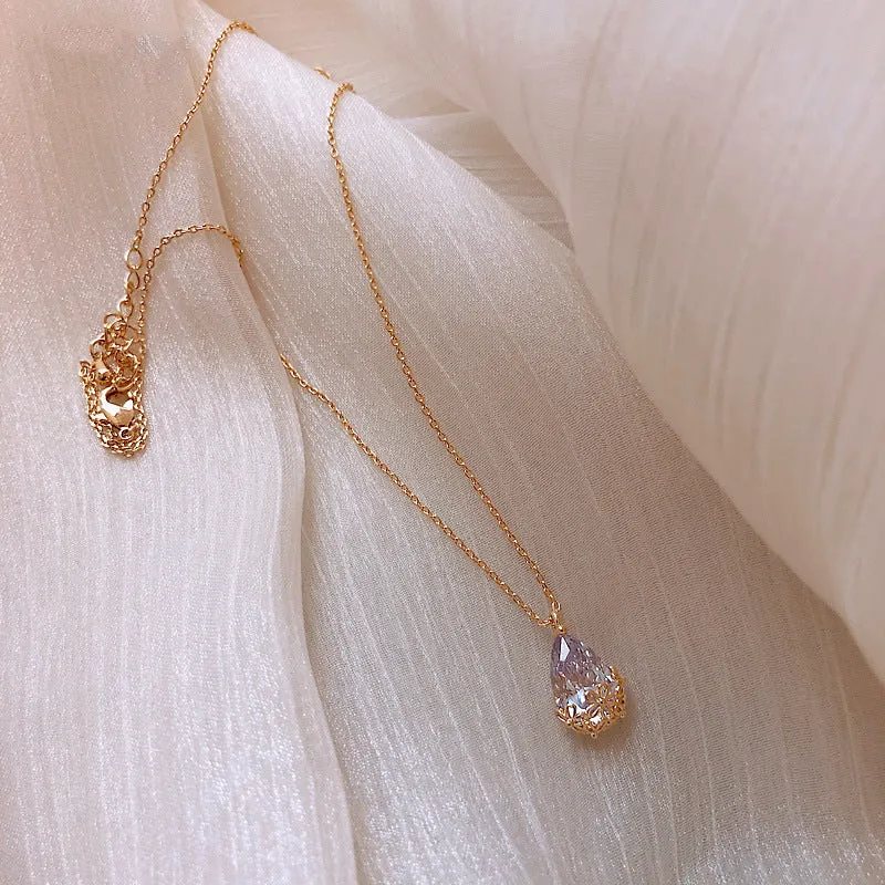 Crystal water drop pendant necklace on a woman, adjustable silver plated chain, clear drop shape pendant close up