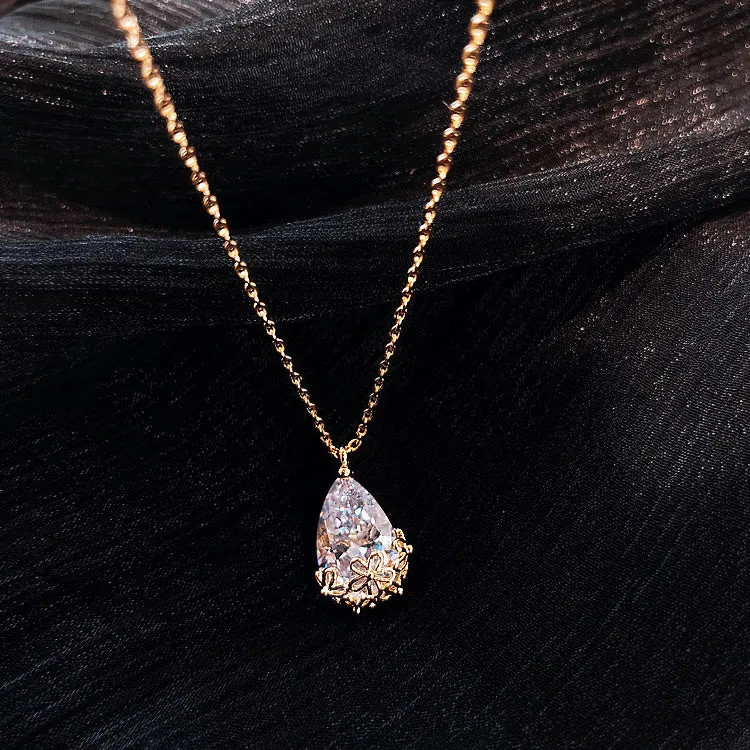 Crystal water drop pendant necklace on a woman, adjustable silver plated chain, clear drop shape pendant close up