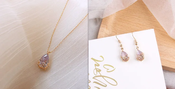 Crystal water drop pendant necklace on a woman, adjustable silver plated chain, clear drop shape pendant close up