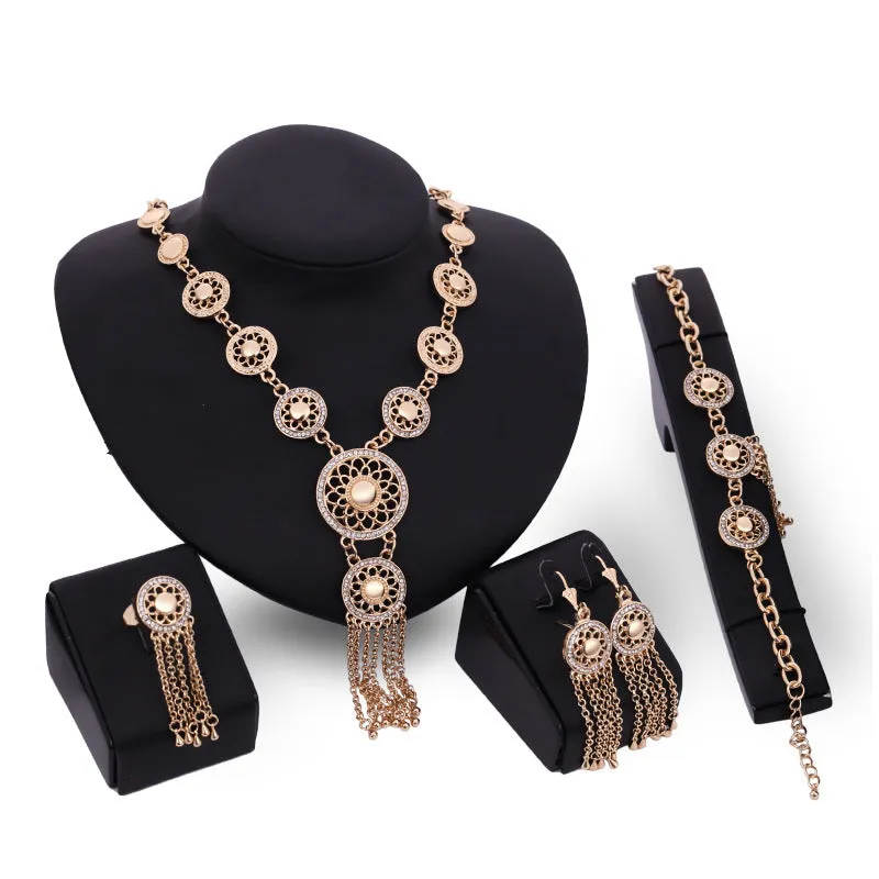 Gold alloy jewellery set with earrings, necklace, and bracelet featuring star and celestial pattern on a light background