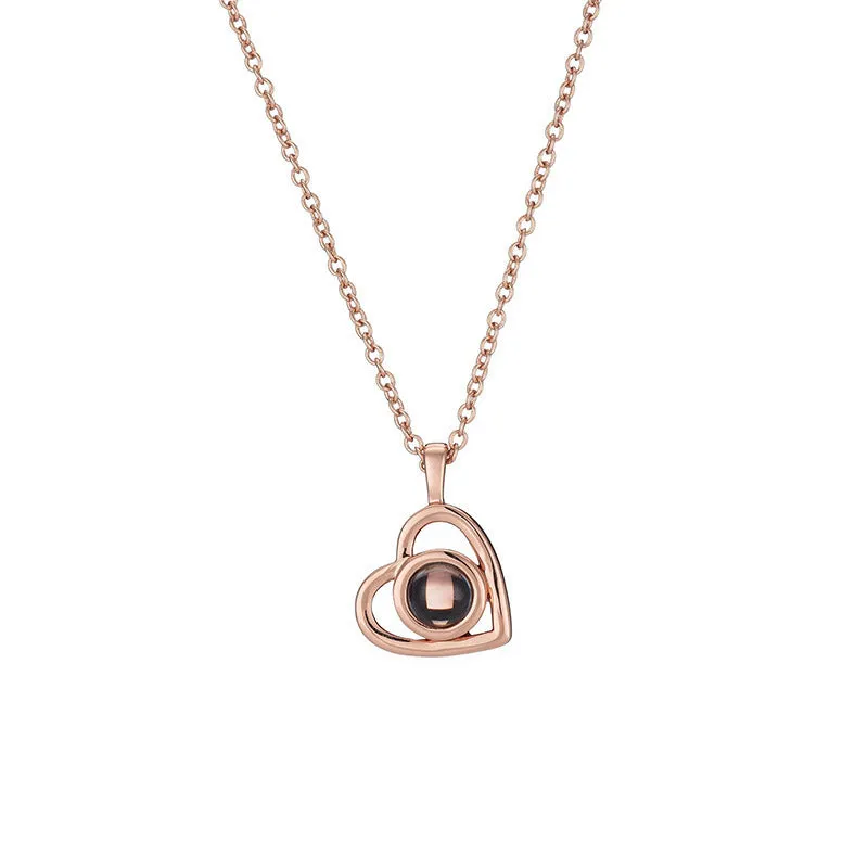 100 Languages I Love You necklace with heart-shaped charm showing custom photo projection inside, in gold finish